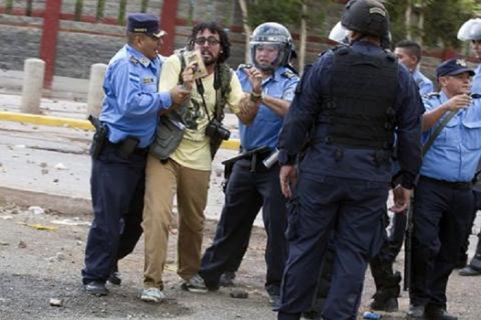 En la foto el periodista Cesario Padilla es reprimido por policías cuando cubría el conflicto en la UNAH 